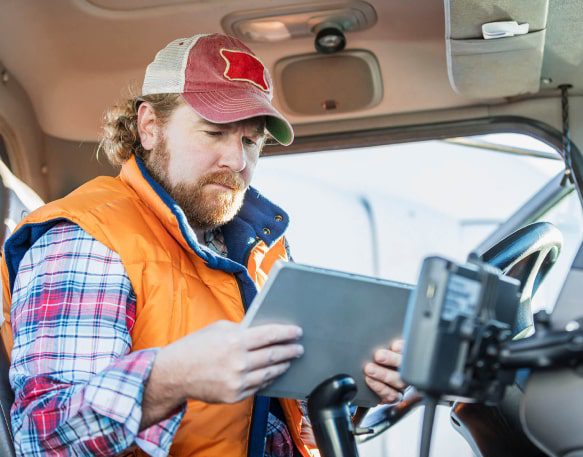 DAT People Driver In Cab Looking At Tablet