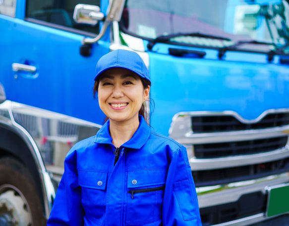 A Commercial Truck Driver Stands In Front Of Her Truck