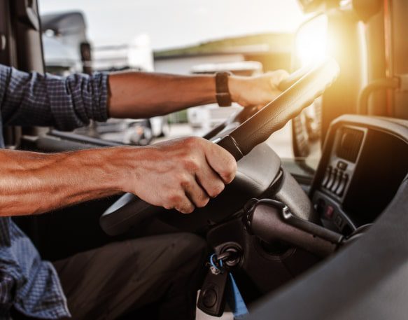 A Driver Sits Behind The Wheel Of Their Truck Min