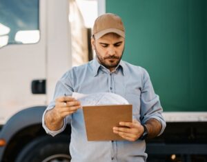 A Trucker Reviews Information On A Clipboard