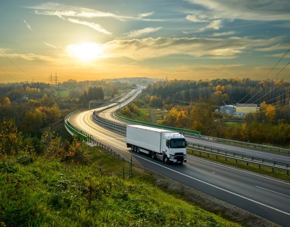 Box Truck Driving Down A Tree Lined Highway