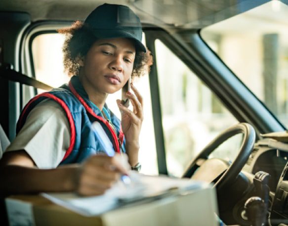 Truck Driver Filling Out Paperwork In Her Cab
