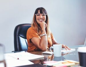 DAT People Broker Woman Smiling At Desk