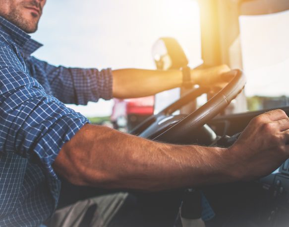 A Long Haul Trucker Sits Behind The Wheel Of His Truck Min