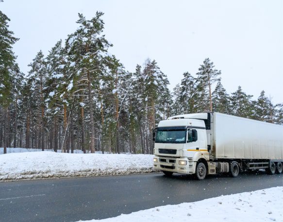 A Truck Drives Down A Highway In Winter Min