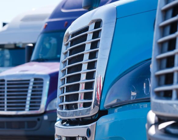 Fronts Of Several Large Trucks Parked In A Line Min