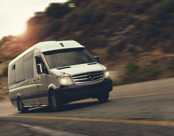 Sprinter Van Driving Down A Highway Min