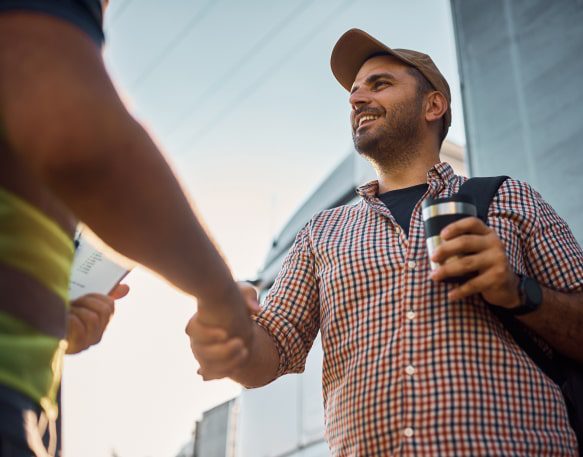 Two People Shake Hands Sealing The Deal On An Owner Operator Lease Agreement Min