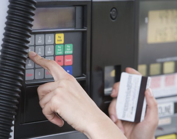 A truck driver uses their fuel card to pay at the pump.