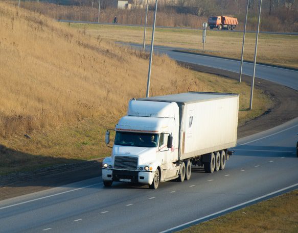 Box truck with LTL freight drives down an open highway.