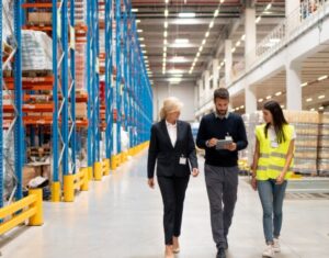 Freight shipping manager talks to a carrier in the warehouse.