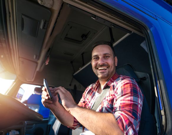 Truck driver smiling at camera as he completes a trucking job.