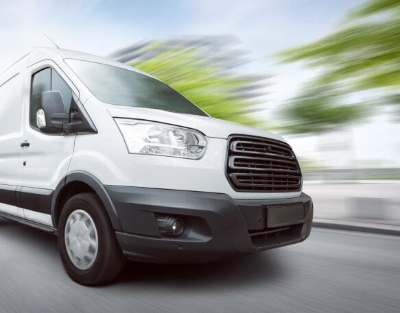 A cargo van driving down a road.