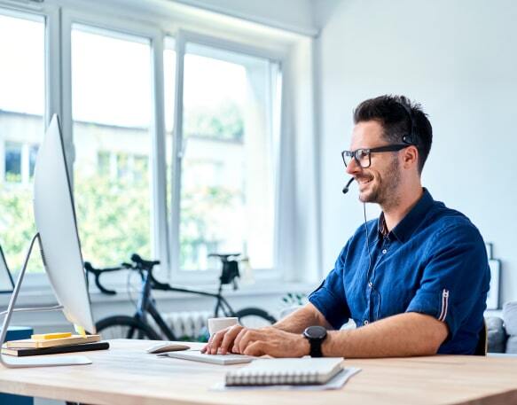 Freight broker sitting at a computer working in his home office.