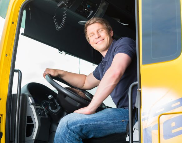 Smiling truck driver sitting in their yellow truck.