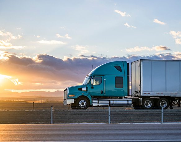 Semi-truck-driving-on-the-road-at-sunset