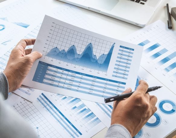 A person is holding a piece of paper with a graph on it