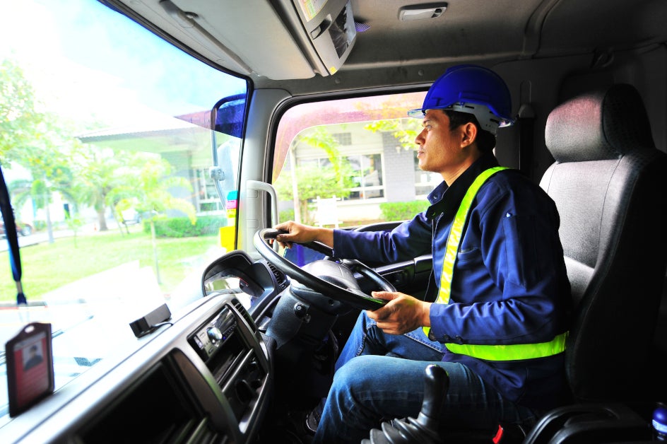 A commercial truck driver safely steers a truck.