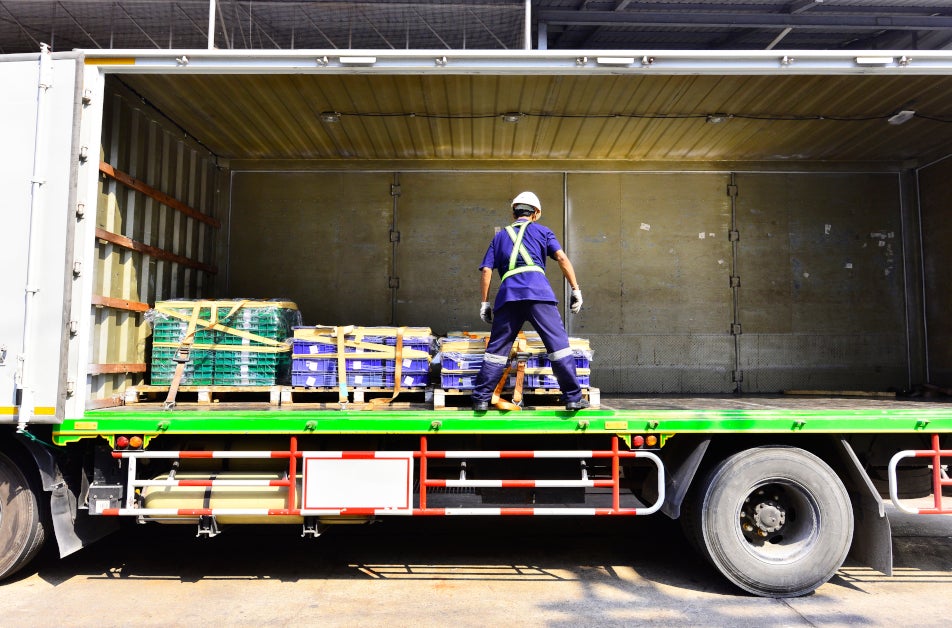 A worker ensures that all loads are properly secured.