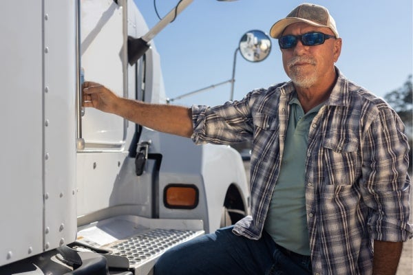 An owner-operator stands by his truck, preparing to open the door.