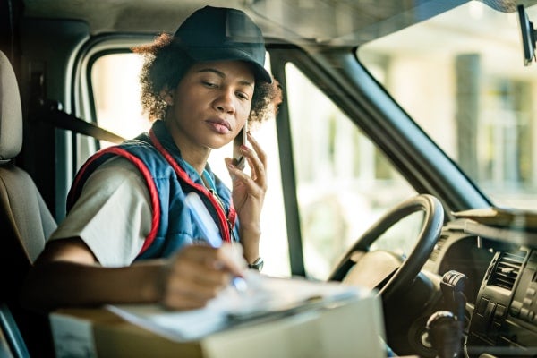 Truck driver filling out paperwork in her cab.