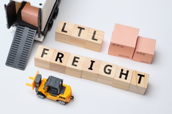 A toy forklift moves building blocks to spell out LTL FREIGHT.