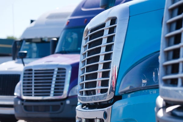 Fronts of several large trucks parked in a line.
