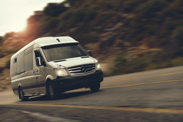 Sprinter van driving down a highway.