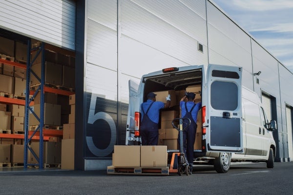 Two people load a cargo van.