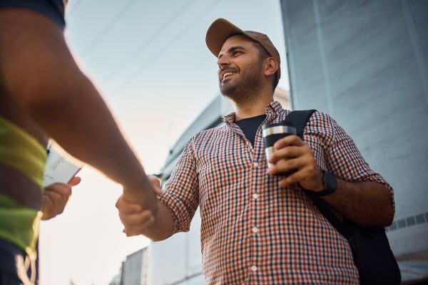 Two people shake hands, sealing the deal on an owner-operator lease agreement.