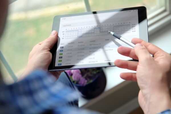 Man logging trucking data on a tablet.