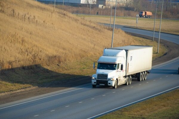 Box truck with LTL freight drives down an open highway.