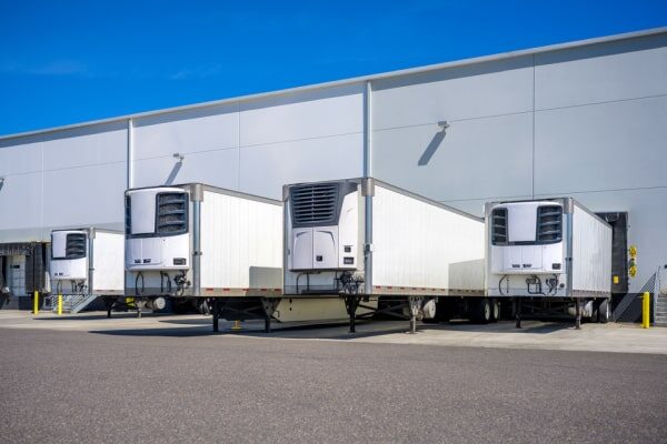 Row of temperature controlled trucking trailers.